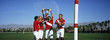 Polo team celebrating with trophy on field