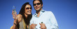 Couple celebrating with champagne outdoors, portrait