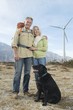 Senior couple with dog near wind farm
