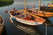 Wooden sailing boats at sunset, reflected in the quiet water Wooden sailing boats at sunset, reflected in the quiet water