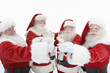 Group of men dressed as Santa Claus toasting champagne