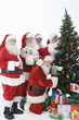 Group of men dressed as Santa Claus decorating Christmas tree