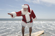 Father Christmas surfboards at the waters edge