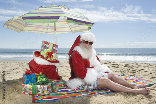 Photo: Father Christmas sits under a parasol on the beach Father Christmas sits under a parasol on the beach