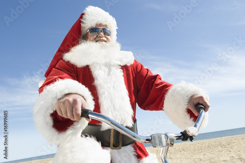 Photo: Father Christmas cycles along beach front Father Christmas cycles along beach front
