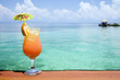 A refreshing tropical drink, with an island in the background A refreshing tropical drink, with an island in the background