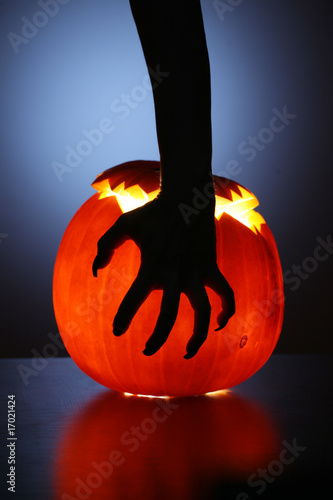 Photo: Hand over Halloween pumpkin Hand over Halloween pumpkin