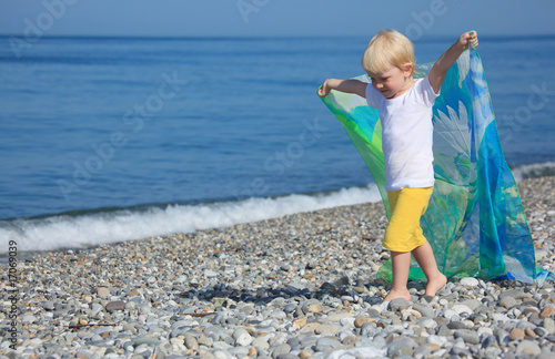 Photo: child with shawl goes on pebble beach child with shawl goes on pebble beach