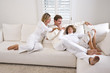 Family relaxing at home on white living room sofa