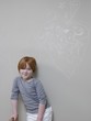 7-8 Year old girl stands below chalk drawing on wall