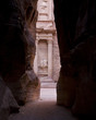 Photo: the ancient treasury at petra seen through the cracks of the rocks at the siq the ancient treasury at petra seen through the cracks of the rocks at the siq