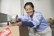 Cheerful Asian woman working in distribution warehouse
