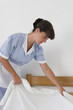 Femme de chambre en train de faire les draps
