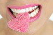 Heart shape candy on woman macro mouth Heart shape candy on woman macro mouth