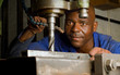 African American with drill press