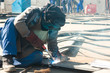 welder with protective mask welding metal and sparks
