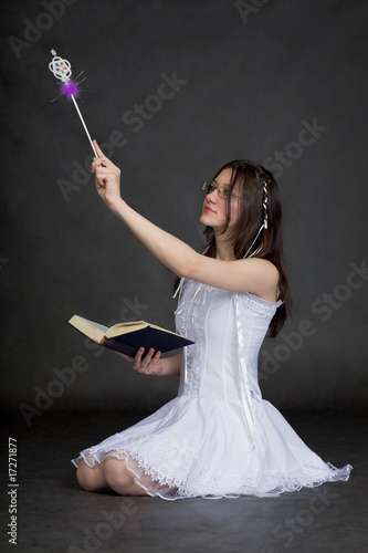 Photo: Girl in suit of the fairy with magic wand on black background Girl in suit of the fairy with magic wand on black background