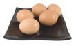 five eggs laying on black plate isolated on white background