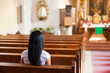 Frau betet in einer Kirche