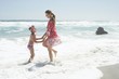mother and daughter paddling on beach
