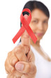 Woman pointing red ribbon badge to camera