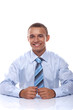 Portrait of a smiling young businessman sitting by the table in Portrait of a smiling young businessman sitting by the table in