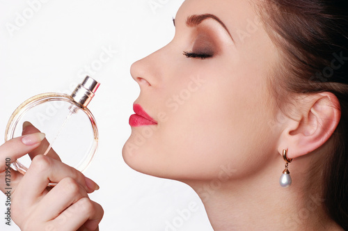 Beautiful young woman smelling her perfume Beautiful young woman smelling her perfume