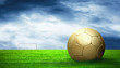 Soccer ball on green grass and sky background