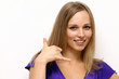funny woman making call-me gesture standing indoors