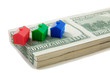 Stack of cash with models of houses in a row