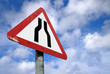 Old British road narrows on both sides ahead warning sign.