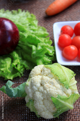 Photo: Baby cauliflower close up, on brown canvas Baby cauliflower close up, on brown canvas