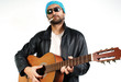young guy in dark glasses and bandana, with a guitar