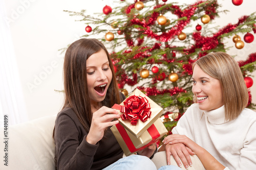 Photo: Young woman unpacking Christmas gift Young woman unpacking Christmas gift