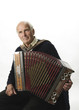 Nachdenklicher Seniorenmusiker mit historischer Ziehharmonika