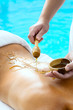 Back of a young woman getting a spa treatment