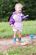 Cute little girl playing in the mud with ice cream scoops.
