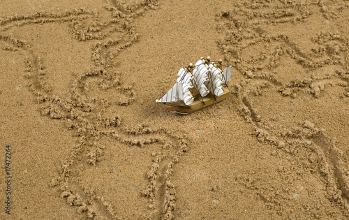 Photo: Ship on sand wit global map outline Ship on sand wit global map outline
