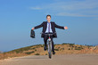 Carefree businessman holding a briefcase and riding a bicycle Carefree businessman holding a briefcase and riding a bicycle