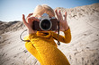 woman with a old camera taking photos in the desert woman with a old camera taking photos in the desert