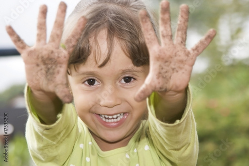 Photo: Beautiful girl showing her dirty hands Beautiful girl showing her dirty hands