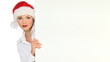 Girl in santa claus hat holding empty board