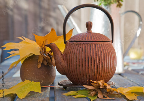 Photo: autumn tea - still life with japanese teapot and maple leaves an autumn tea - still life with japanese teapot and maple leaves an