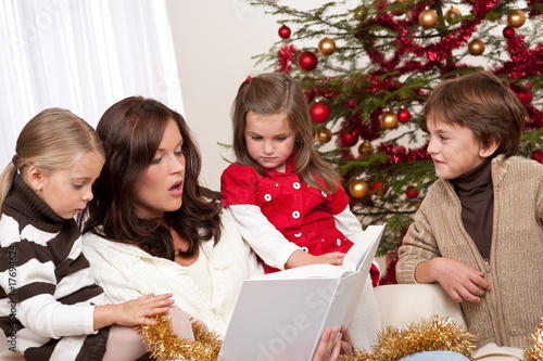 Photo: Happy family: mother with three children on Christmas Happy family: mother with three children on Christmas