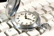 Ancient pocket watch on the computer keyboard
