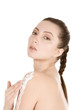 Beautiful young female applies moisturizer on back