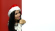 Girl in santa claus hat holding empty board