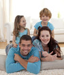 Parents, daughter and son on floor in living-room