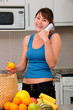 woman on phone laughing while unpacking groceries