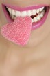 Heart shape candy on woman macro mouth Heart shape candy on woman macro mouth